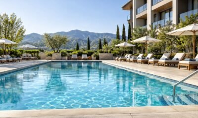 Clean hotel swimming pool with organized deck chairs and landscaping