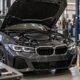European sedan with its hood open beside diagnostic equipment in a workshop
