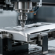 5-axis CNC milling machine fabricating a custom metal chassis for next-gen gaming hardware with coolant mist.