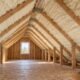 Residential attic with spray foam insulation between timber rafters